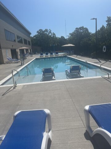 image of aquatic center outdoor pool. including chairs, umbrella tables.