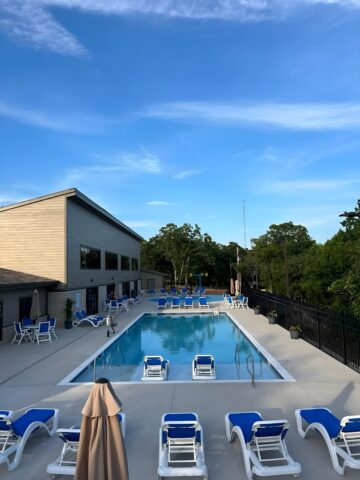 image of aquatic center outdoor pool. including chairs, umbrella tables.